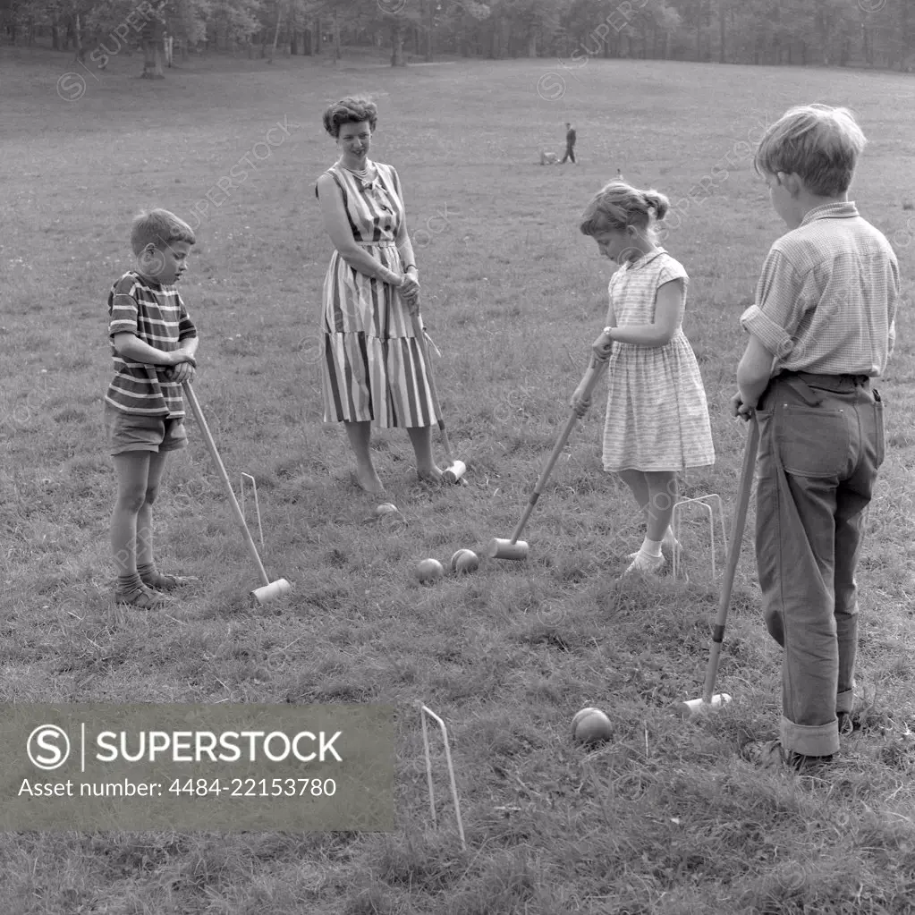 Summer activitiy in the 1950s. A mother and her children are playing croquet. Sweden 1957 Ref 3480