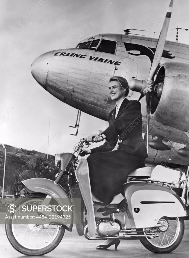 Woman of the 1950s. A young woman with a new Monark moped in front of a passenger plane. 1957