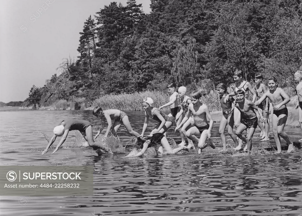 1960s summer. It's a sunny summer day and the children are running into the water. Sweden 1963
