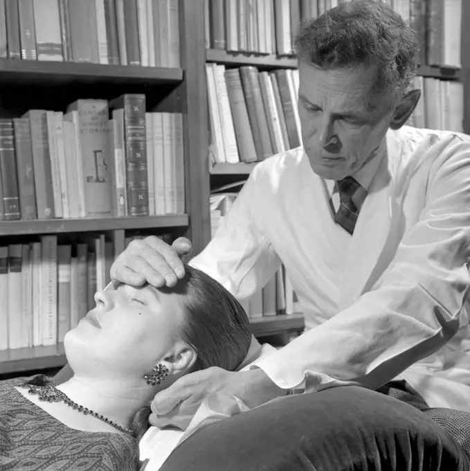At the Psychologist. A  woman is lying on a couch in a psychologist, visibly hypnotized.  Sweden 1954. ref 2776