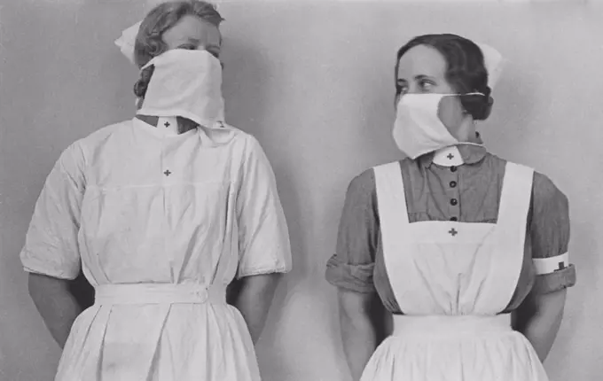 Nurses in the 1930s. Two woman in nurses uniform are wearing protective surgical masks on their faces. A way of not spread bacteria or being infected themselves. Sweden 1930s
