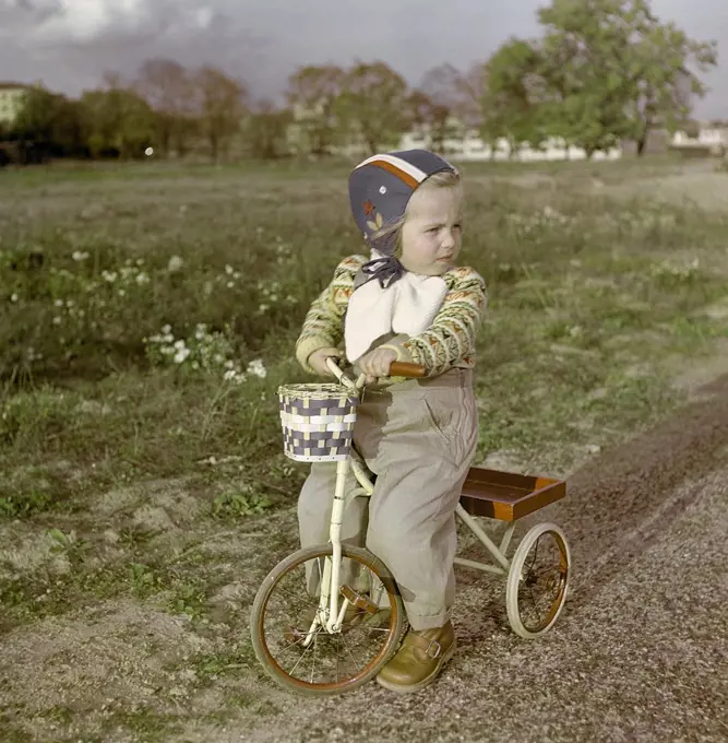 1950s girl on tricycle. A little girl is sitting on her tricycle. Sweden 1950s. ref CV21-4