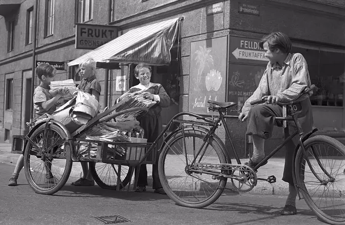 1940s children. Scene from the Swedish movie Kvarterets olycksfågel 1947. The boys are working extra as bicycle messangers and doing deliveries to earn extra money. Sweden 1947
