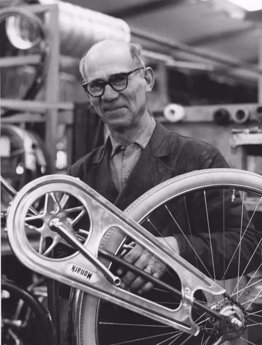 Factory in the 1950s. A worker at the bicycle and motorcycle company Monark in Sweden. He is standing by an bicycle that is nearly finished in production. Sweden 1958
