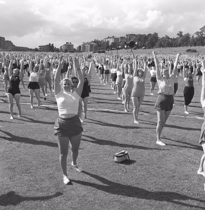 Gymnastics in the 1950s. The popular womens housewife gymnastics is being practiced everywhere. Here a large number of women are exercising together outdoors. Sweden June 1954
