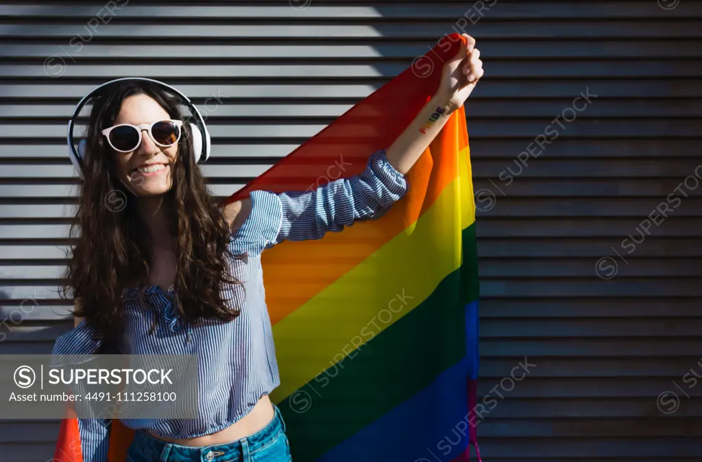 Girl posing happily with the LGBT flag to celebrate gay pride rights