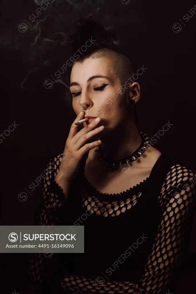 Adult female with mohawk and piercing smoking cigarette