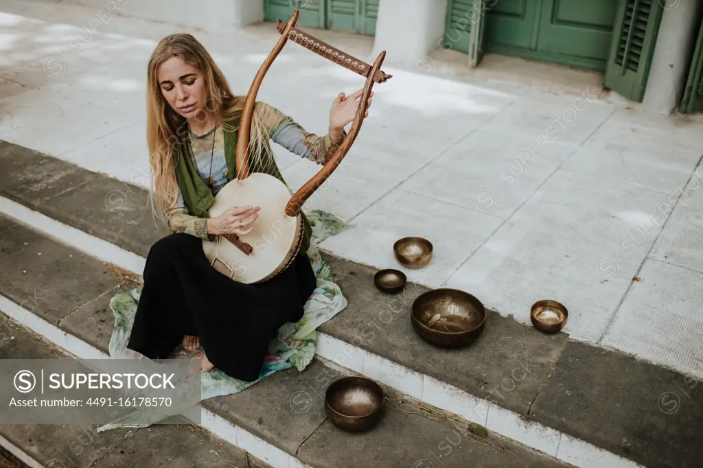 Female playing lyre on steps