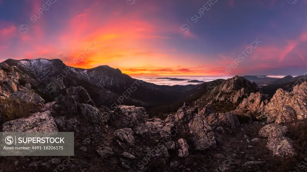 Breathtaking view of mountain ridge located against vivid sundown sky in cloudy evening in nature