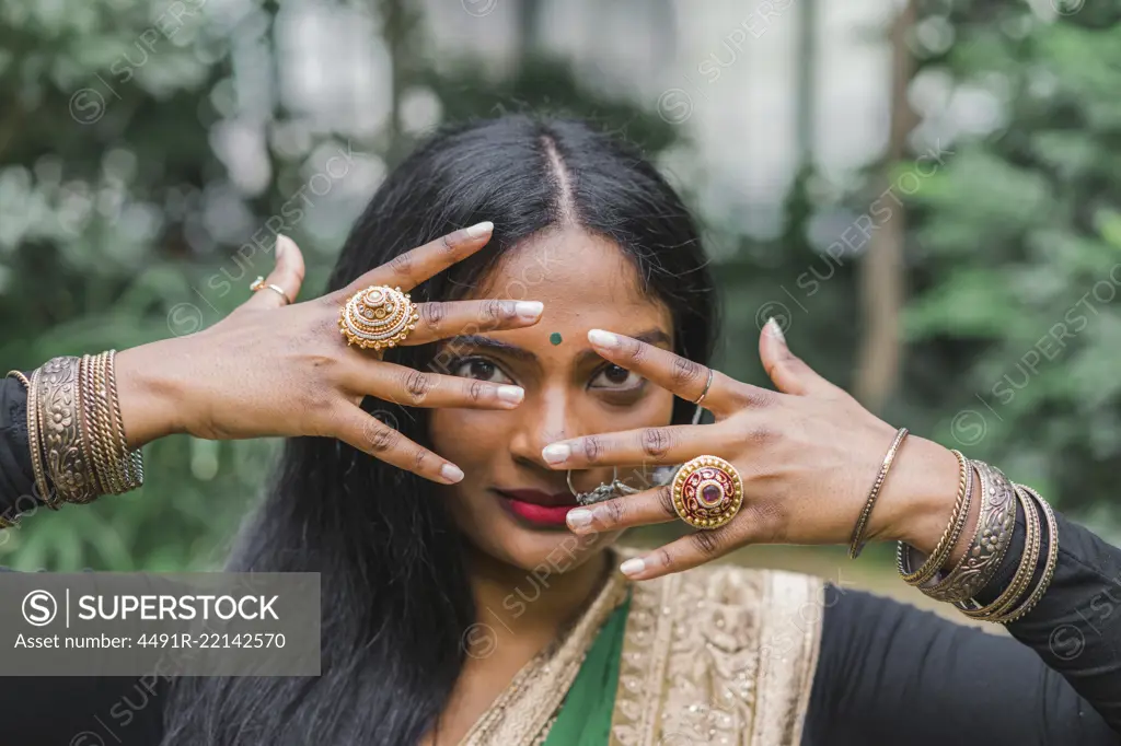 Young beautiful ethnic woman in traditional clothes posing in the garden.