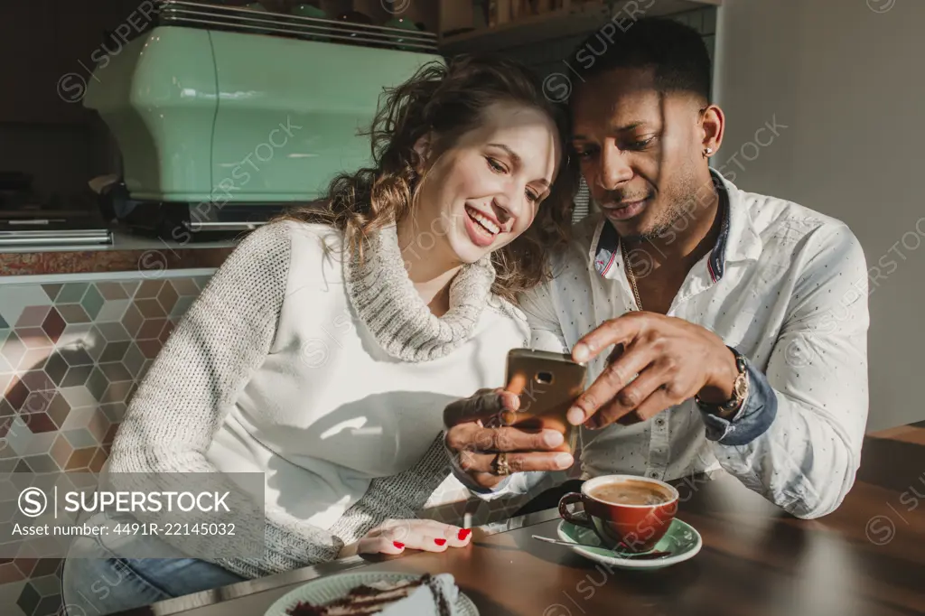 Couple using smartphone in cafe