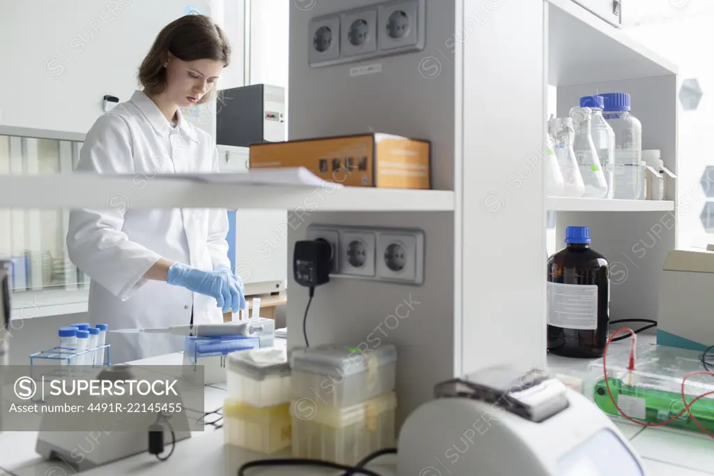 Young woman in whites standing in laboratory and working.