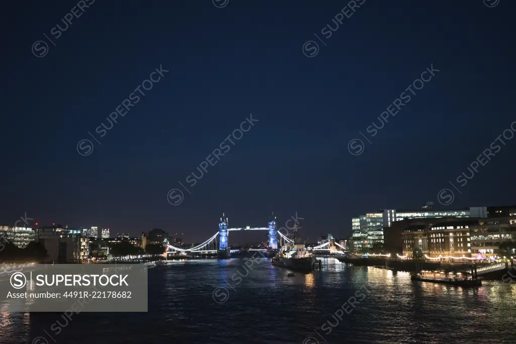 View of beautiful cityscape of London with glowing lights taken from river.