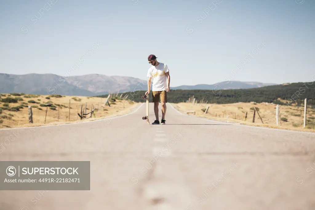 Man with skateboard on road