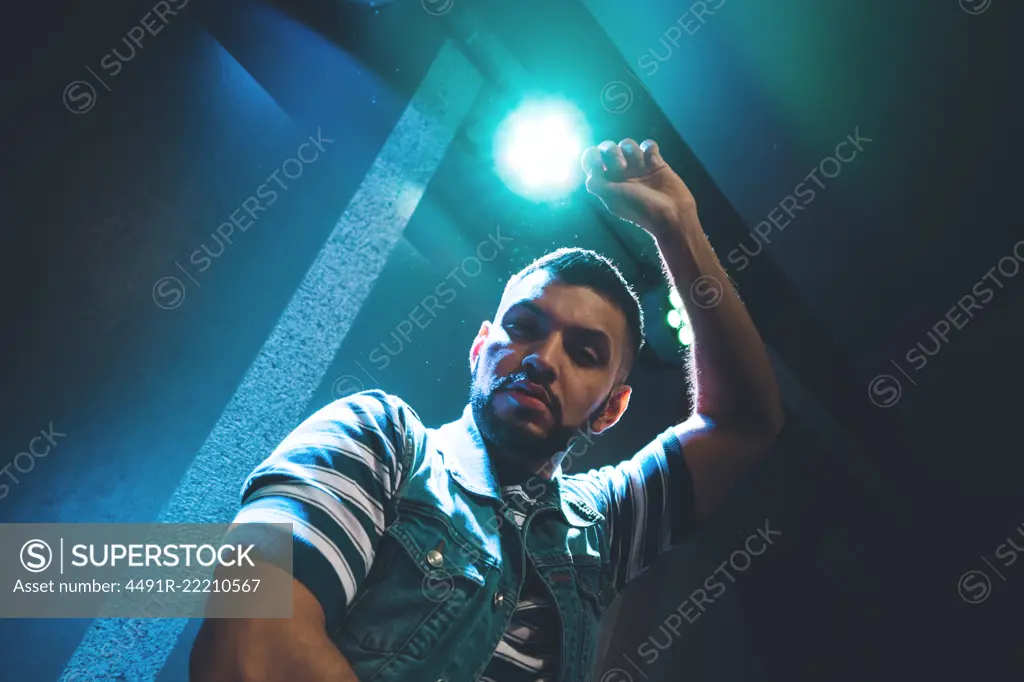 Handsome bearded man dancing in spotlight