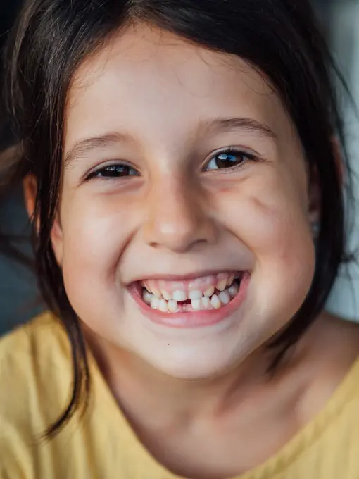 Happy child without tooth looking at camera and cheerfully smiling