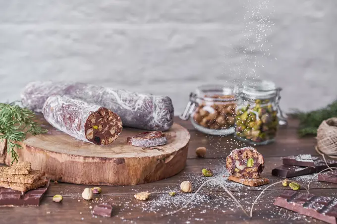 Chocolate salami with nuts on wooden table