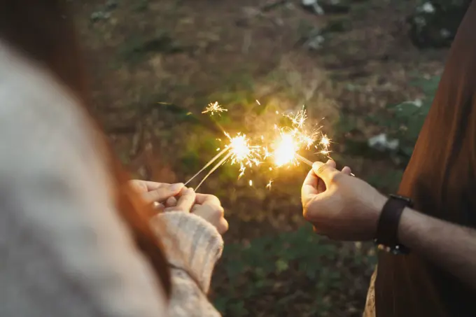 Hands with sparklers in woods