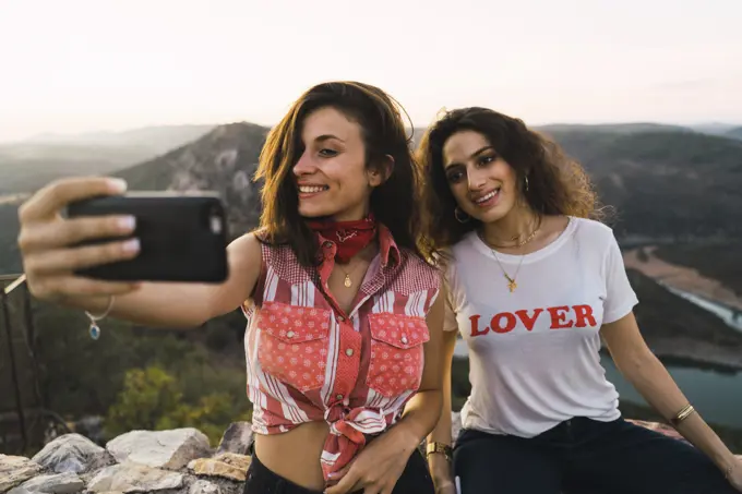 Stylish women taking selfie on breathtaking landscape