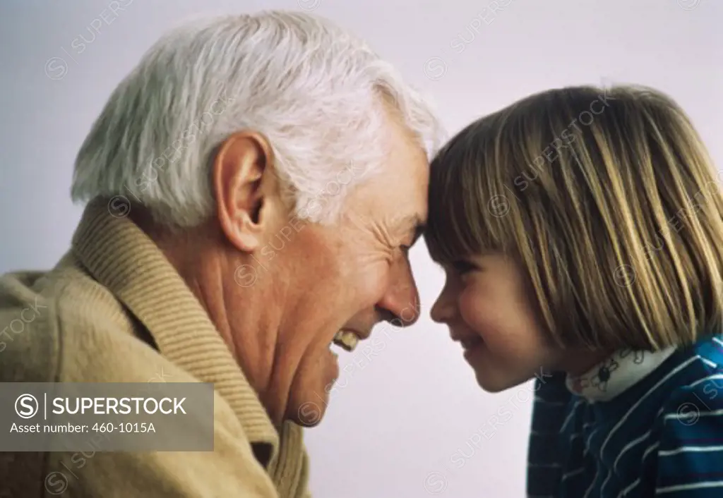 Elderly man and a child smiling looking at each other