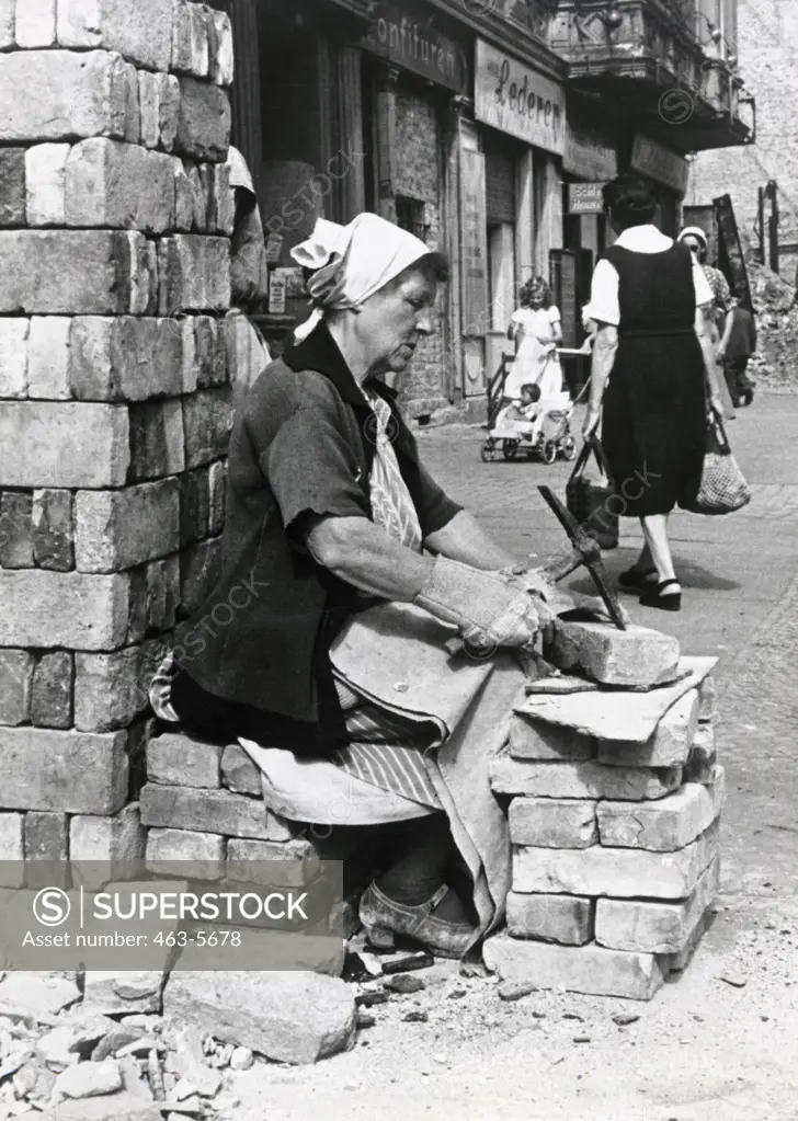 Rubble Woman, a woman cleans bricks to sell, Berlin, Germany