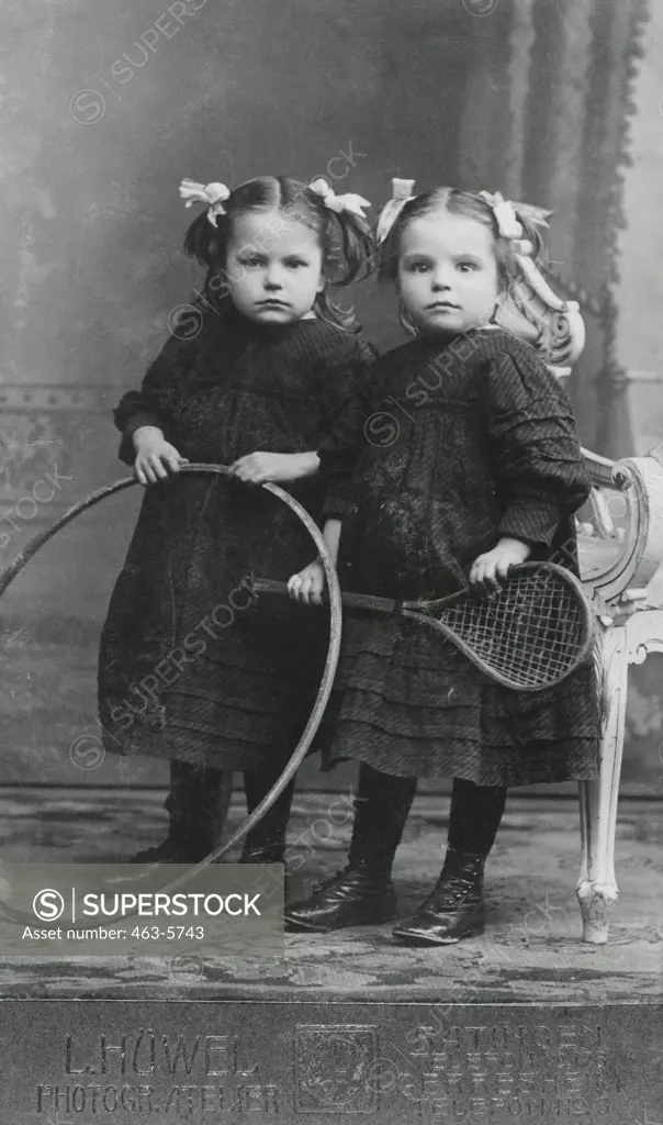 Portrait of two sisters holding a hoop and racket, Berlin, Germany, 1912