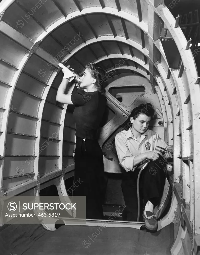 Two women working in an airplane factory