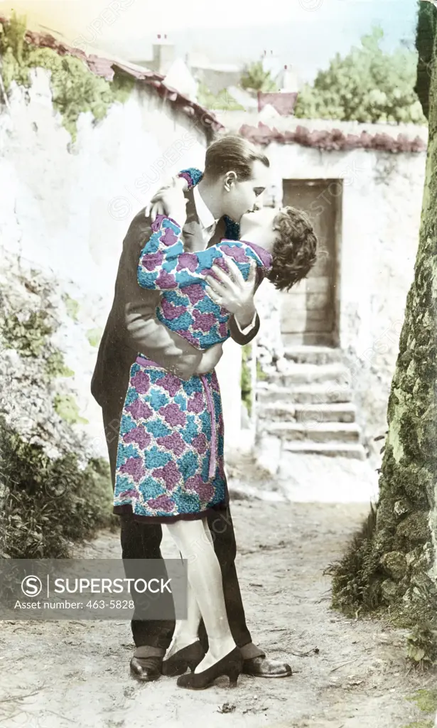 Side profile of a young couple kissing in a street, 1925
