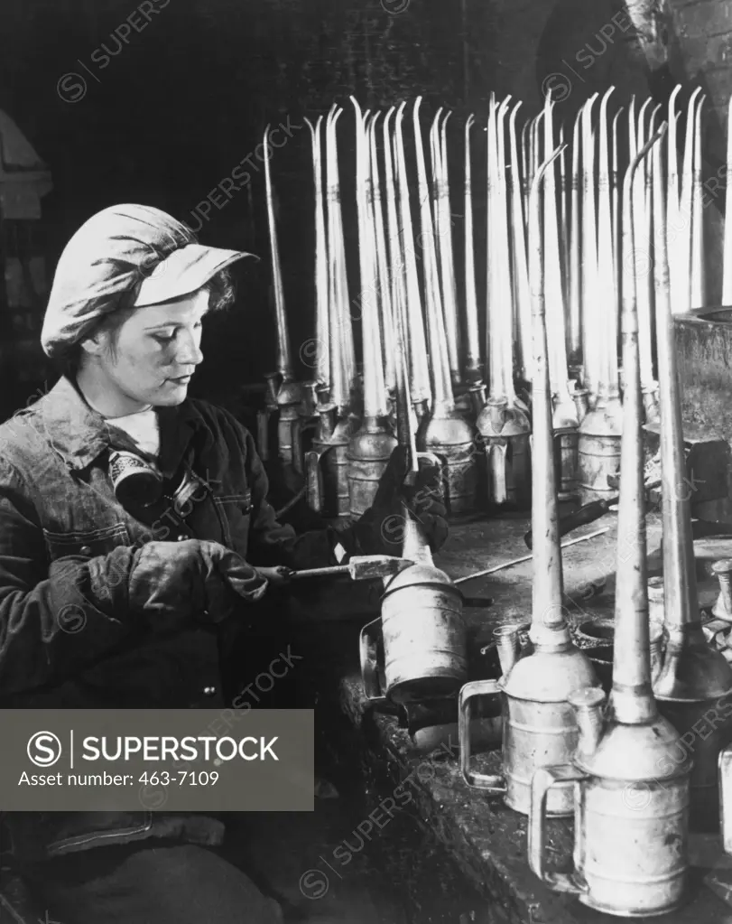 Young woman working on oil cans
