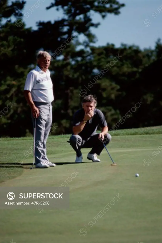 Two mature men playing golf