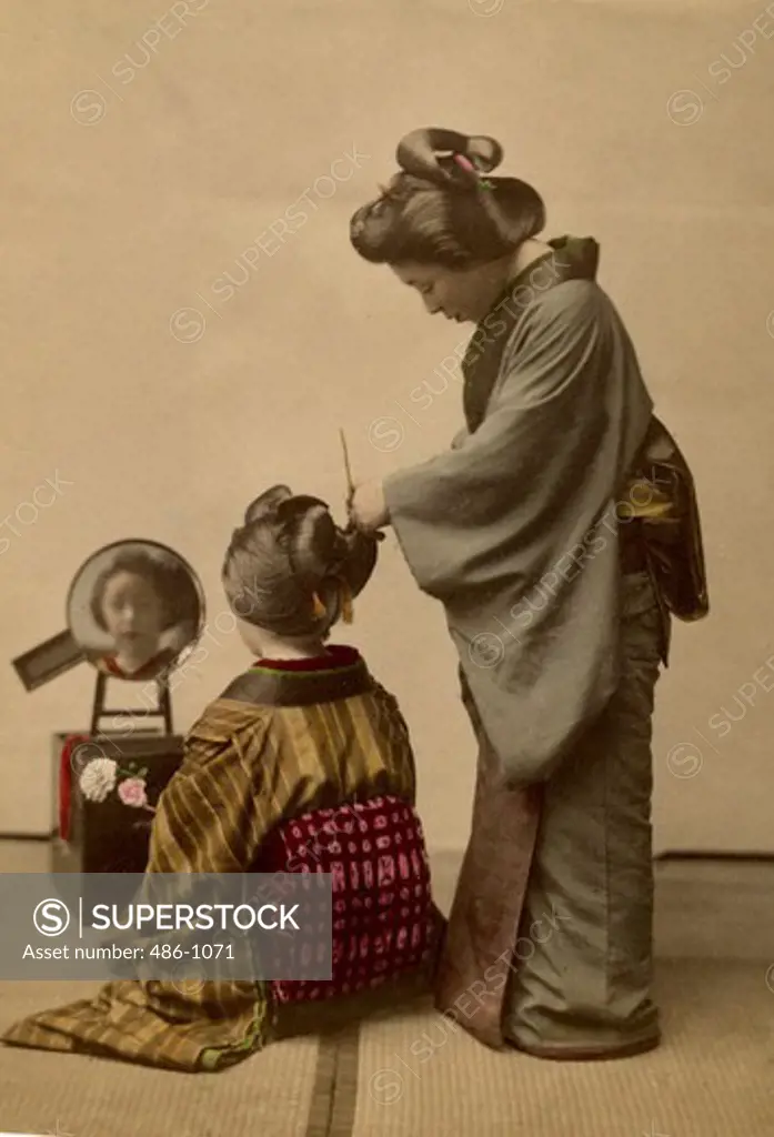 Woman preparing hair bun on girl's hair