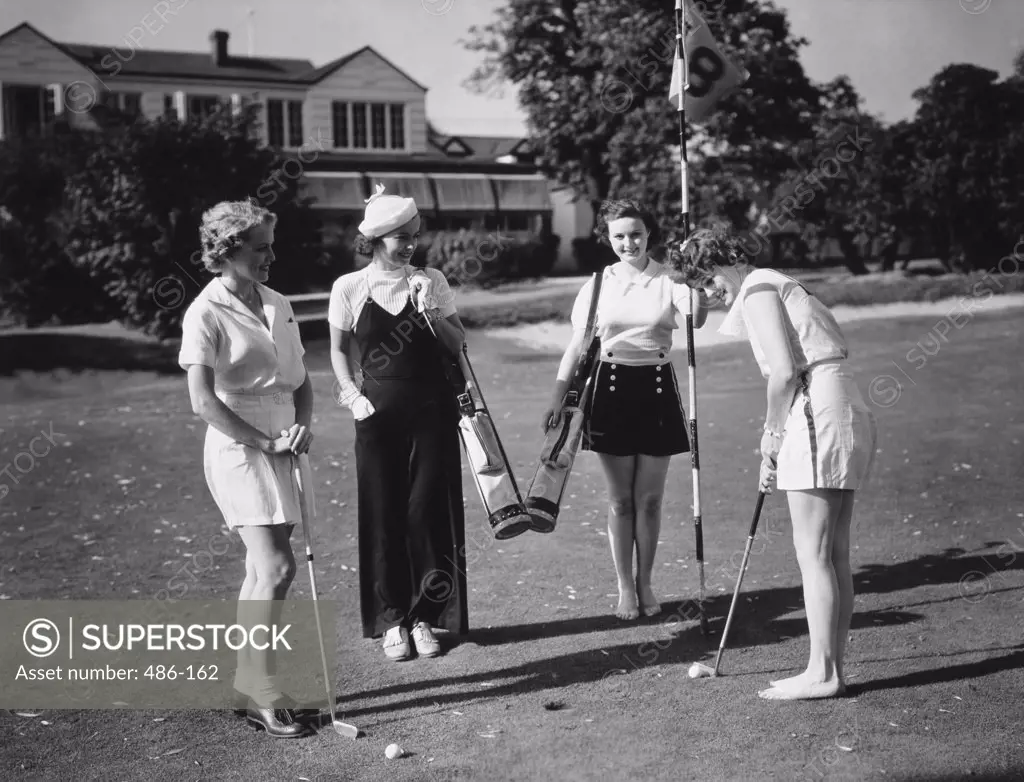 Four women playing golf