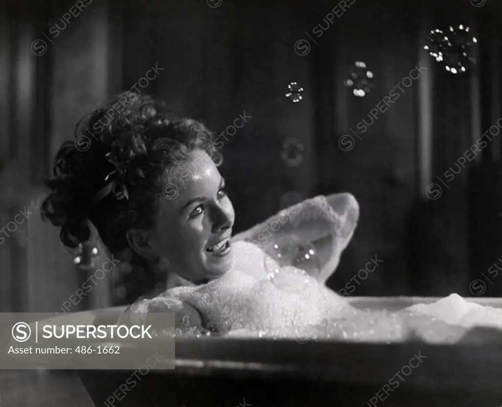 Portrait of young woman enjoying bubble bath