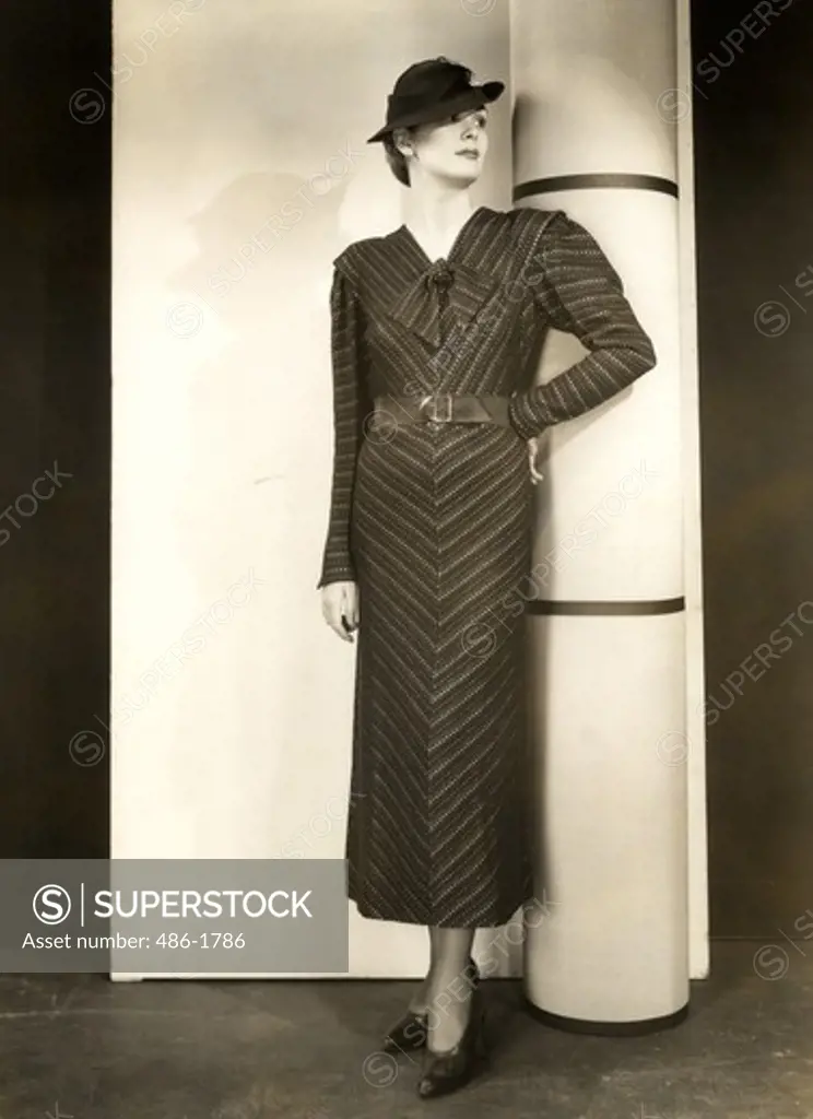 Young woman in long dress posing buy column