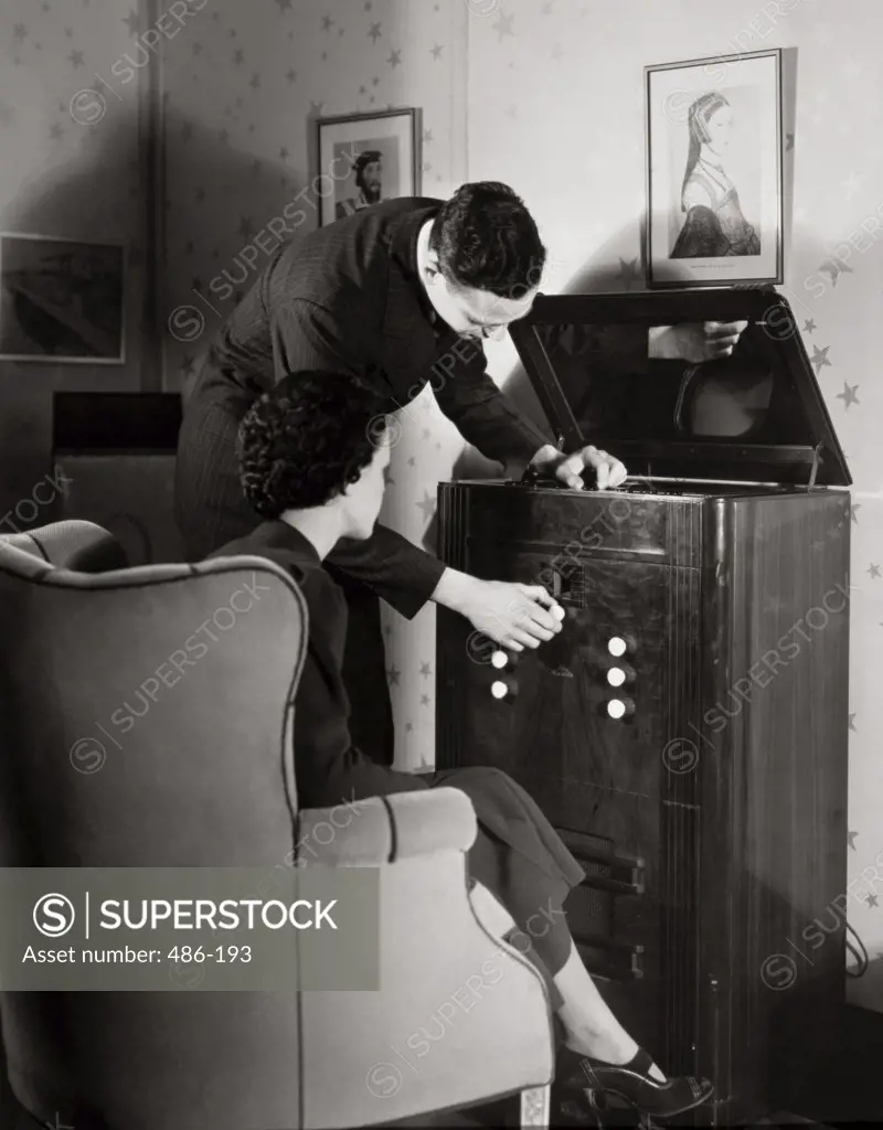 Young man operating a television in a living room, 1937