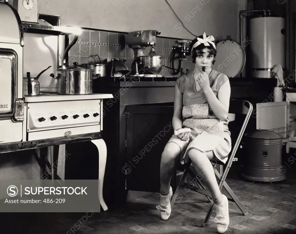 Portrait of a young woman sitting in the kitchen