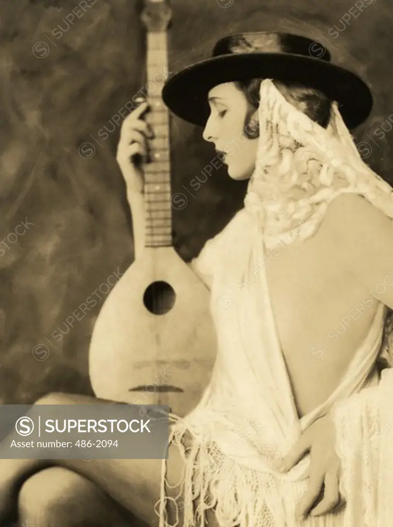 Portrait of young sensual woman holding mandolin