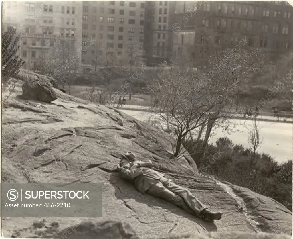 USA, New York City, Central Park, Man Napping On Rock