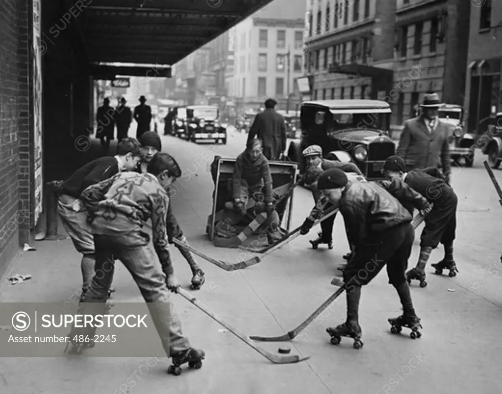 USA, New York City, Boys Playing Roller Hockey In Street