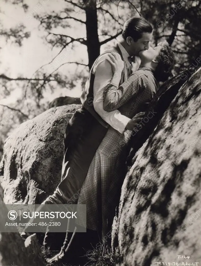 Robert Young and Katharine Hepburn kissing outdoors, from ""Trigger"" (Spitfire), 1934