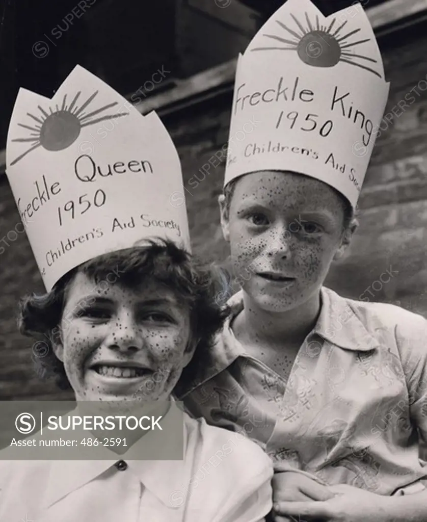 Portrait of boy and girl wearing paper crown
