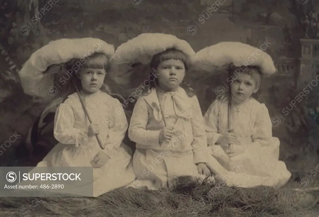 Portrait of three girls with umbrellas