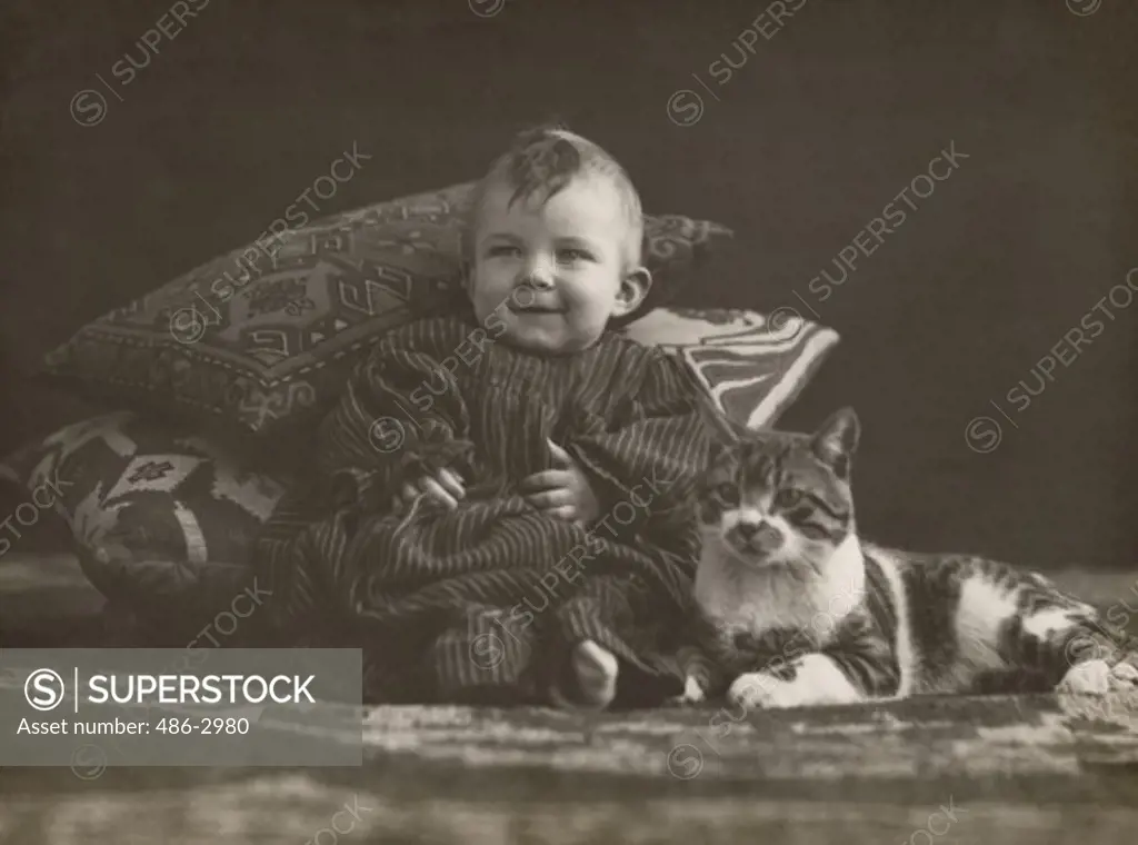 Studio portrait of baby boy with cat