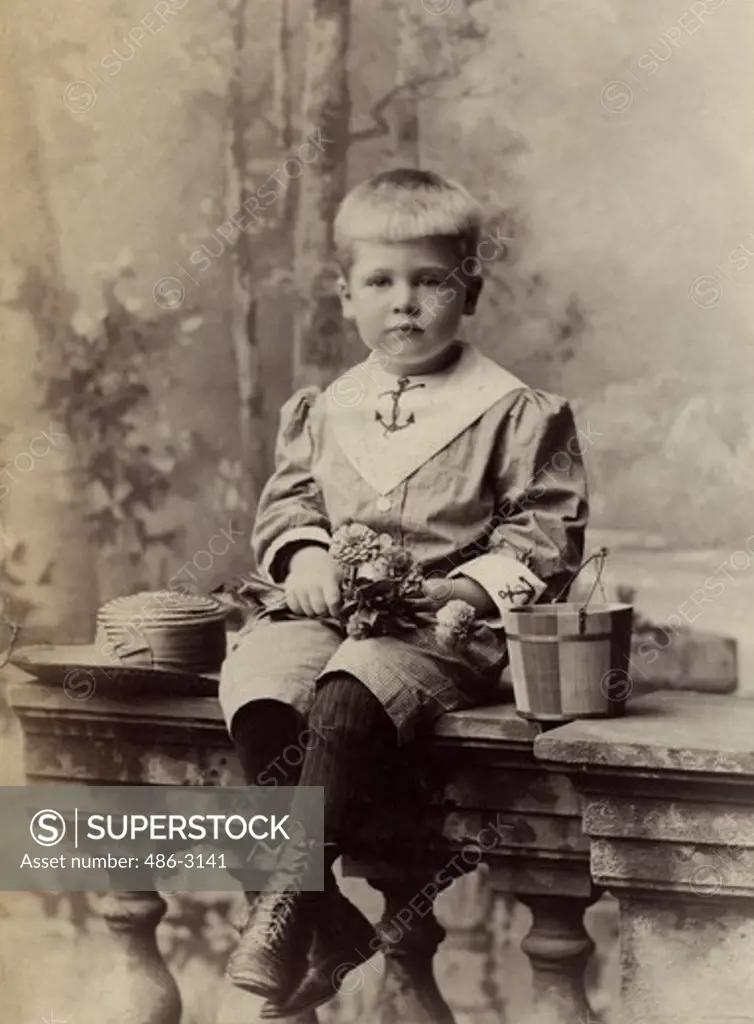 Portrait of sitting boy with hat and bucket, 1890