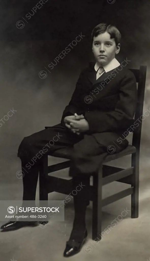 USA, New York, New York City, Portrait of boy sitting on chair, 1911