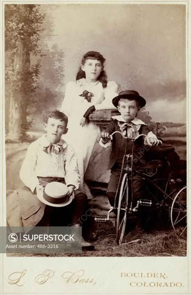Portrait of three children with tricycle