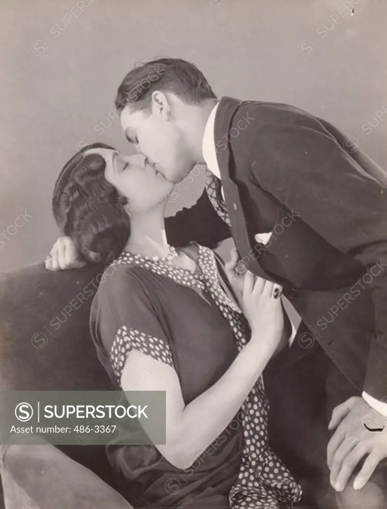 USA, Claud Buchanan and Mona Palma learning right and wrong method of kissing for movies, Kissing. The Paramount Junior Star learn right and wrong method of kissing for the movies. This is wrong. Claud Buchanan of Boston, seems listless because his hands are relaxed. The girl, Mona Palma of New York, anticipates the kiss correctly, but because