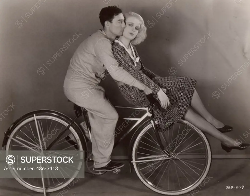Buster Keaton and Anita Page between scenes in MGM's ""Sidewalk of New York"" on Cliff Edwards' bike