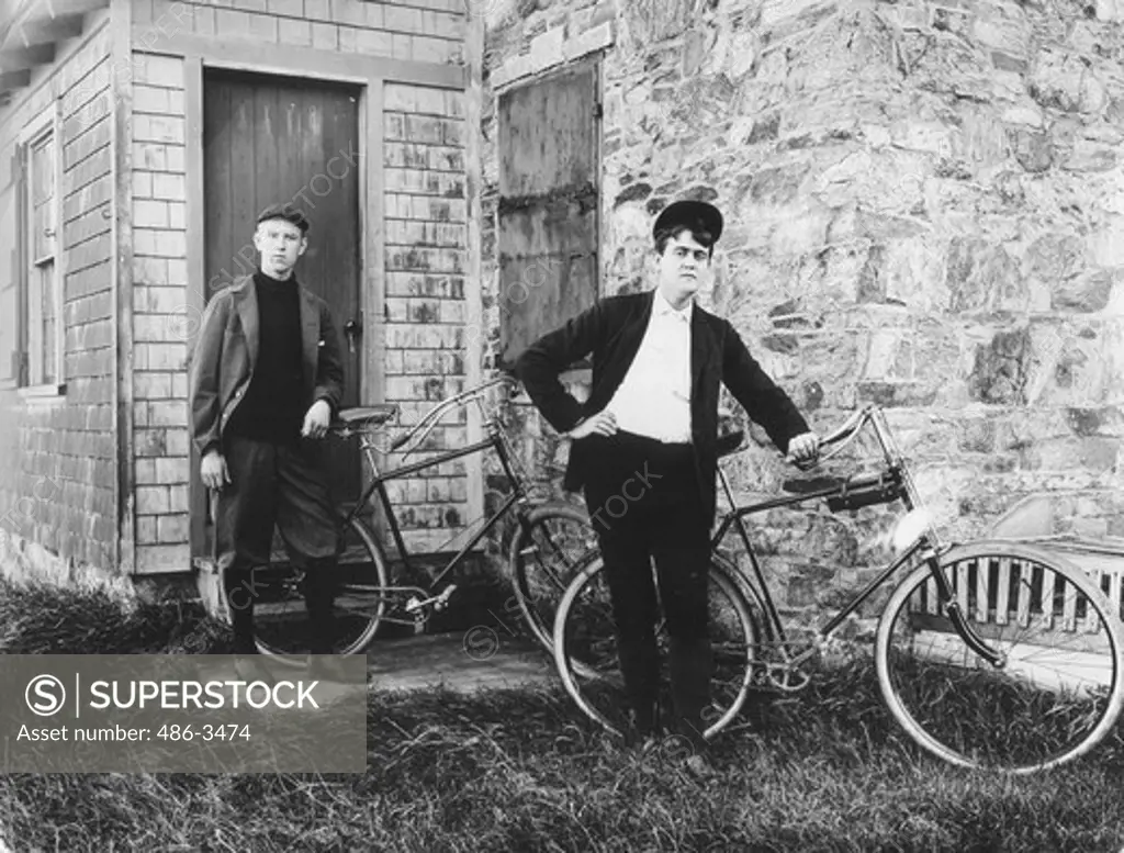 two men posing bicycles