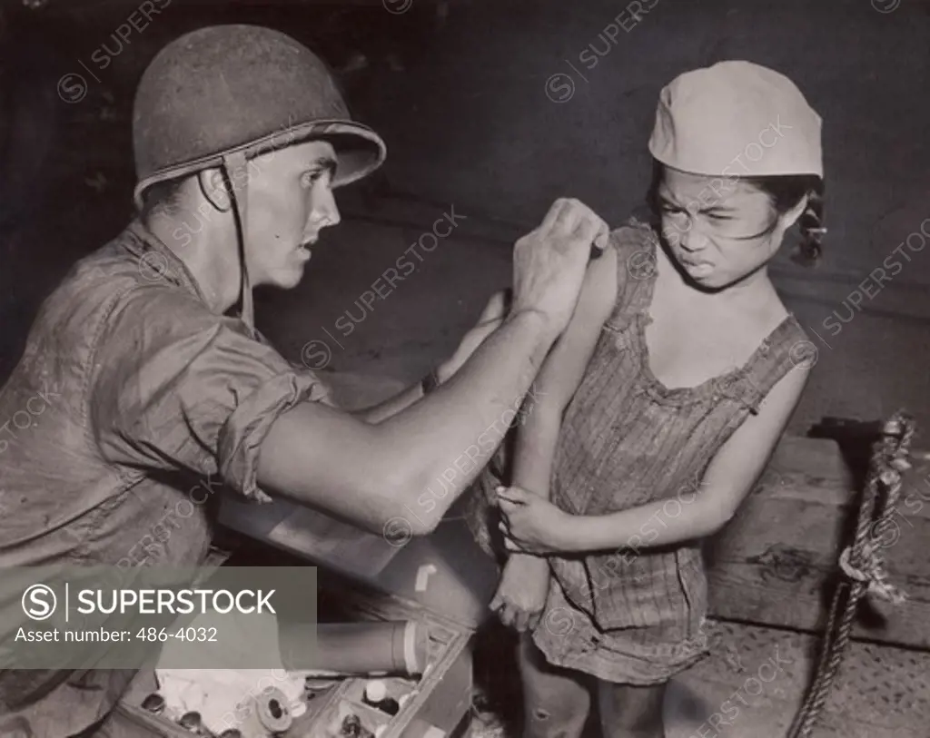 Philippines, Richard D Kepple from navy's Seabees helping girl